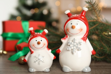 Photo of Christmas composition with decorative snowmen on wooden table