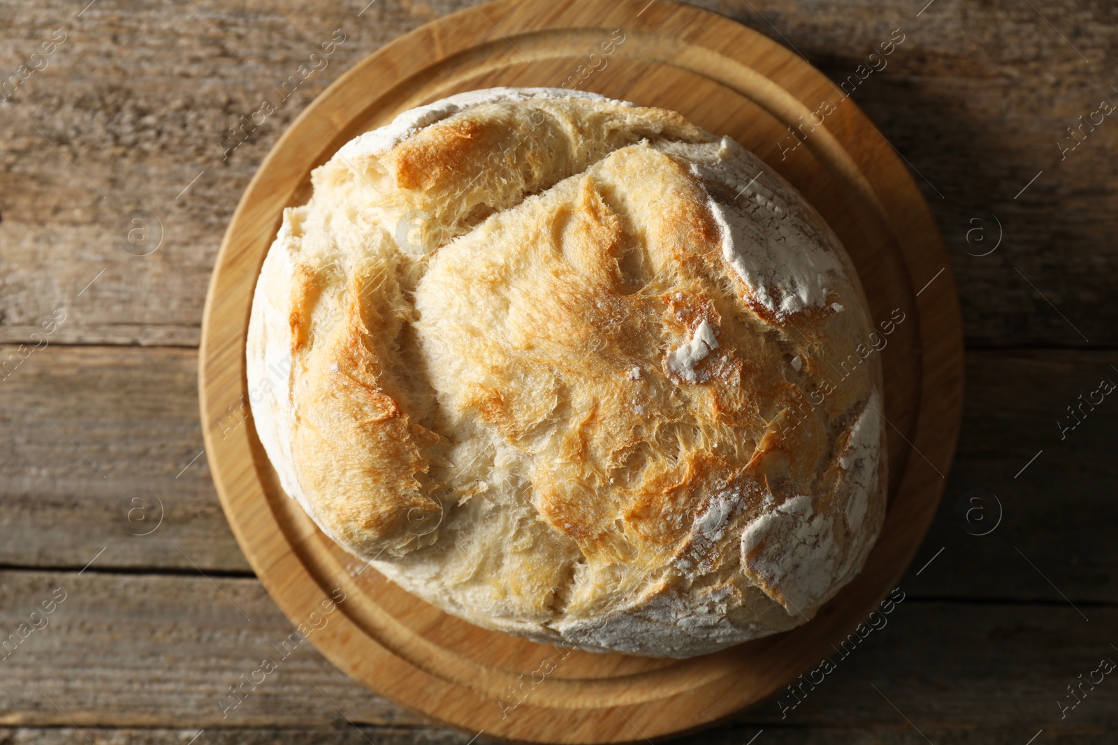 Photo of Freshly baked sourdough bread on wooden table, top view