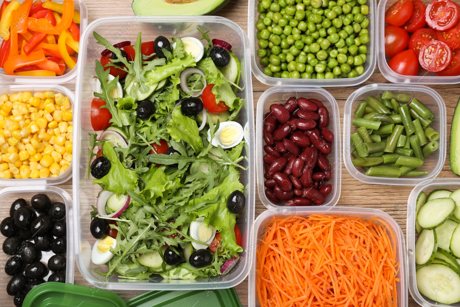 Photo of Set of plastic containers with fresh food on wooden  table, flat lay