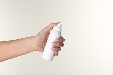 Photo of Woman holding nasal spray on white background, closeup