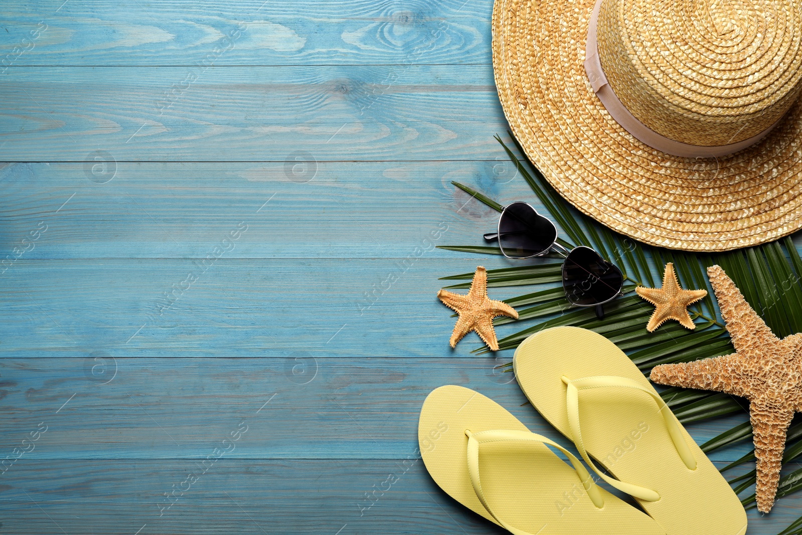 Photo of Flat lay composition with different beach objects on turquoise wooden background, space for text