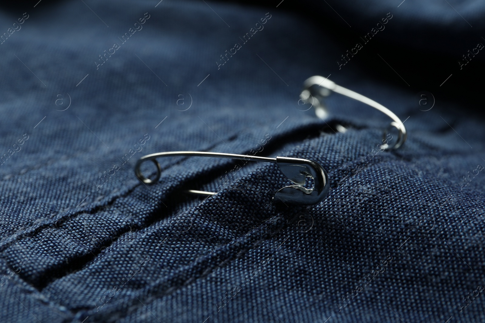 Photo of Closeup view of metal safety pins on clothing