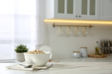 Breakfast time. Tasty oatmeal in bowl on white marble table. Space for text