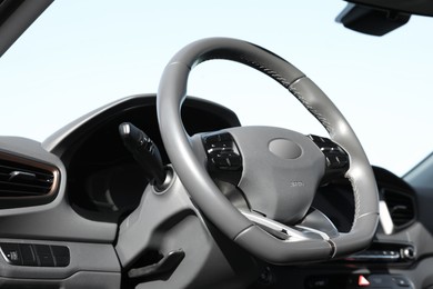 Photo of Black steering wheel and dashboard in modern car