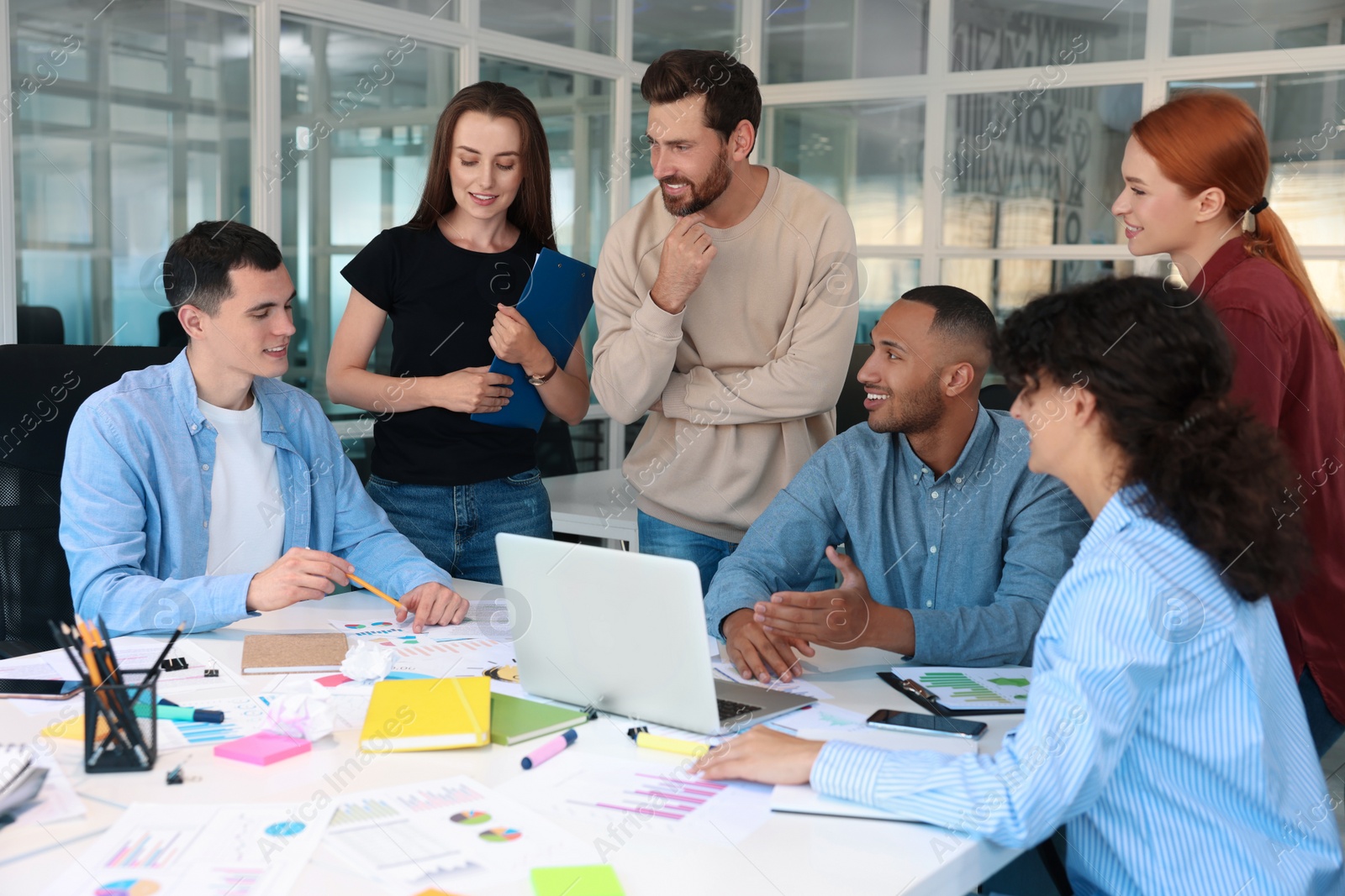 Photo of Team of employees working together at table in office. Startup project