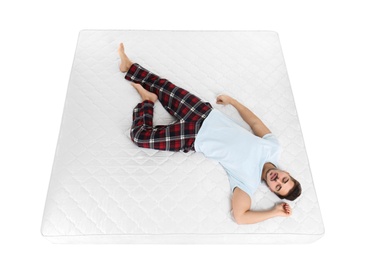 Photo of Young man sleeping on mattress against white background, above view