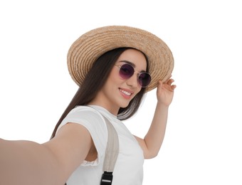 Photo of Smiling young woman in sunglasses and straw hat taking selfie on white background