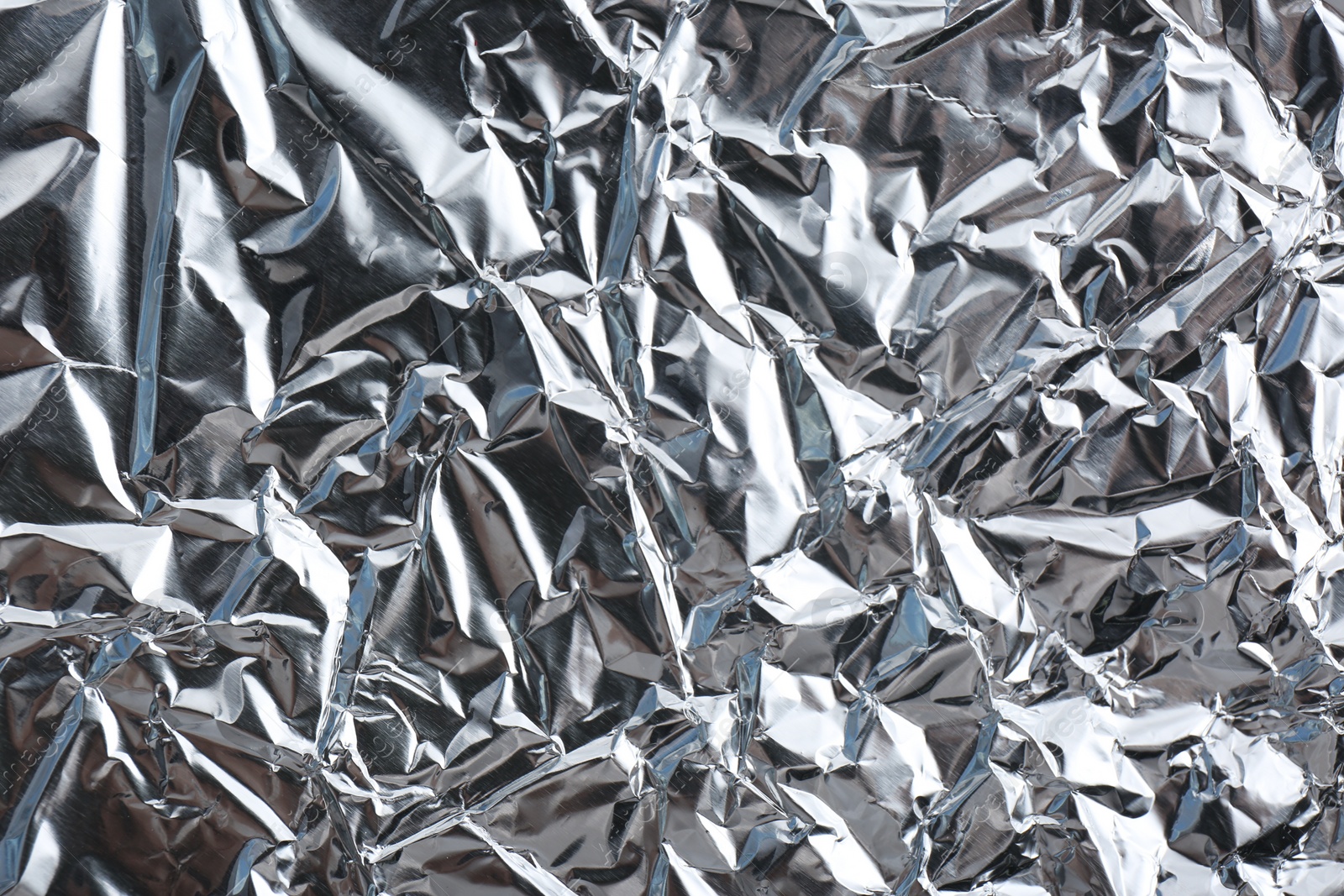 Photo of Crumpled silver foil as background, closeup view