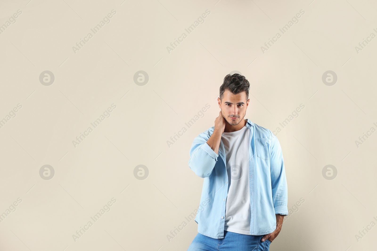 Photo of Young man in stylish jeans on color background with space for text