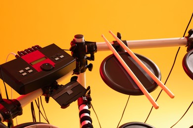 Photo of Modern electronic drum kit on yellow background. Musical instrument