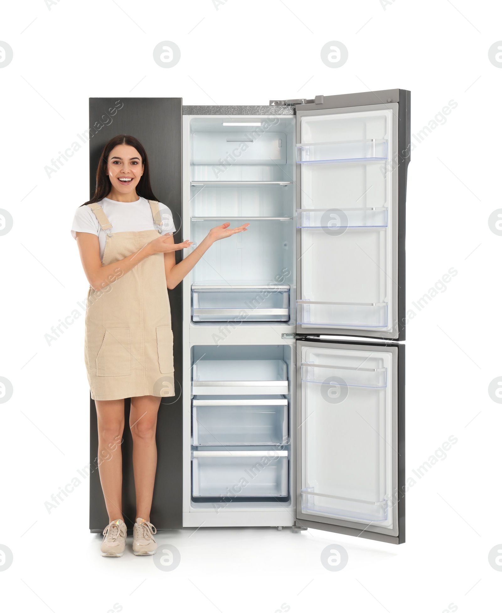 Photo of Young woman near empty refrigerator on white background