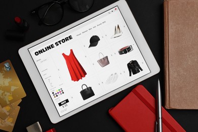 Photo of Online shopping. Flat lay composition with modern tablet on black background