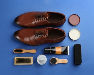Photo of Flat lay composition with shoe care accessories and footwear on blue background