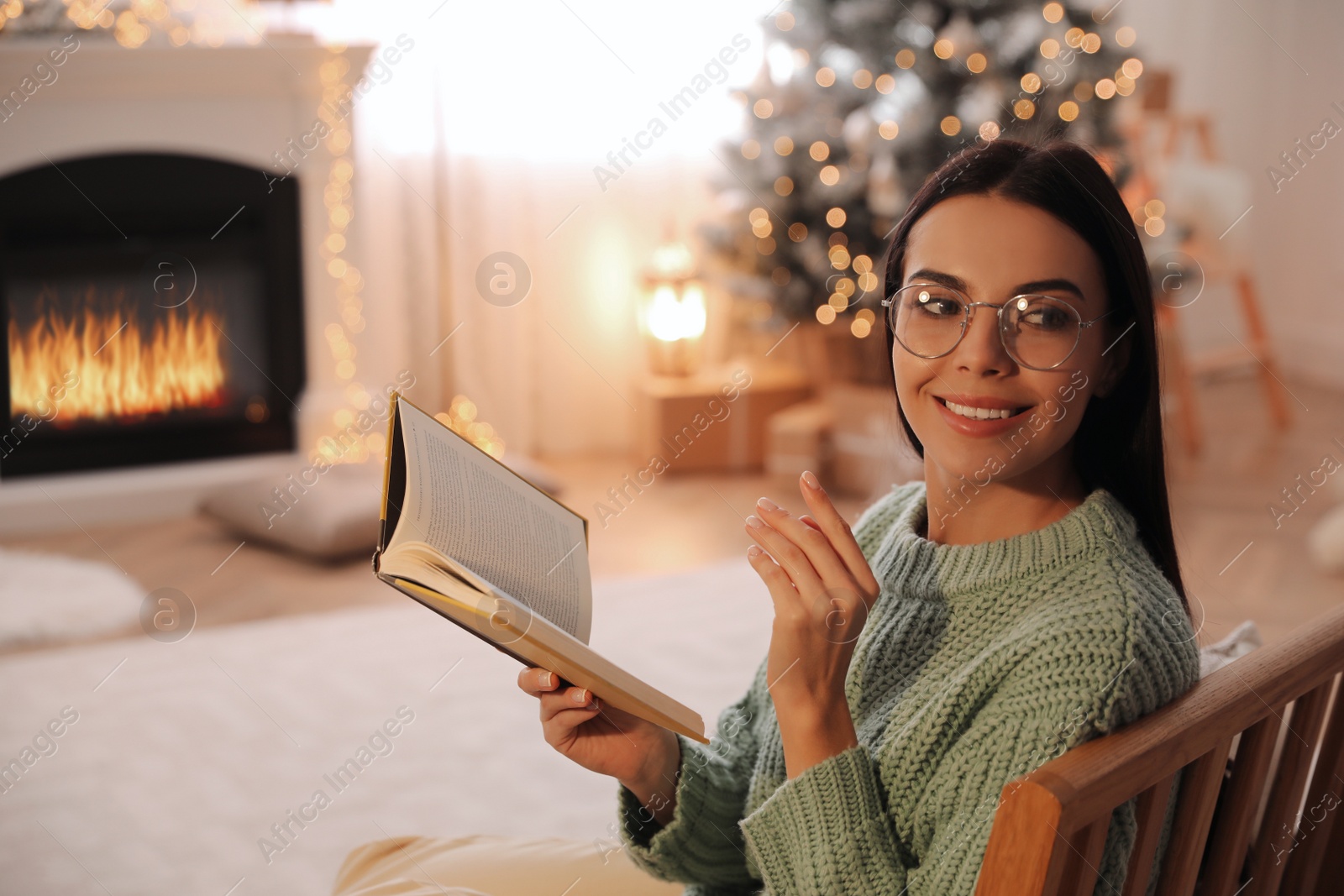 Photo of Young woman with book at home. Christmas celebration