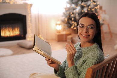 Young woman with book at home. Christmas celebration