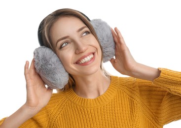 Happy woman wearing warm earmuffs on white background