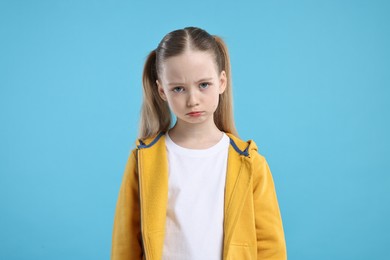 Photo of Portrait of sad girl on light blue background