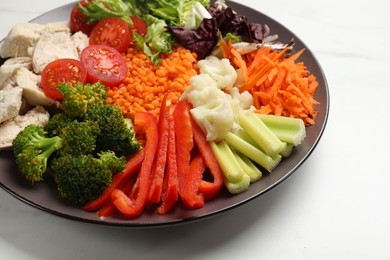 Photo of Balanced diet and healthy foods. Plate with different delicious products on white marble table, closeup