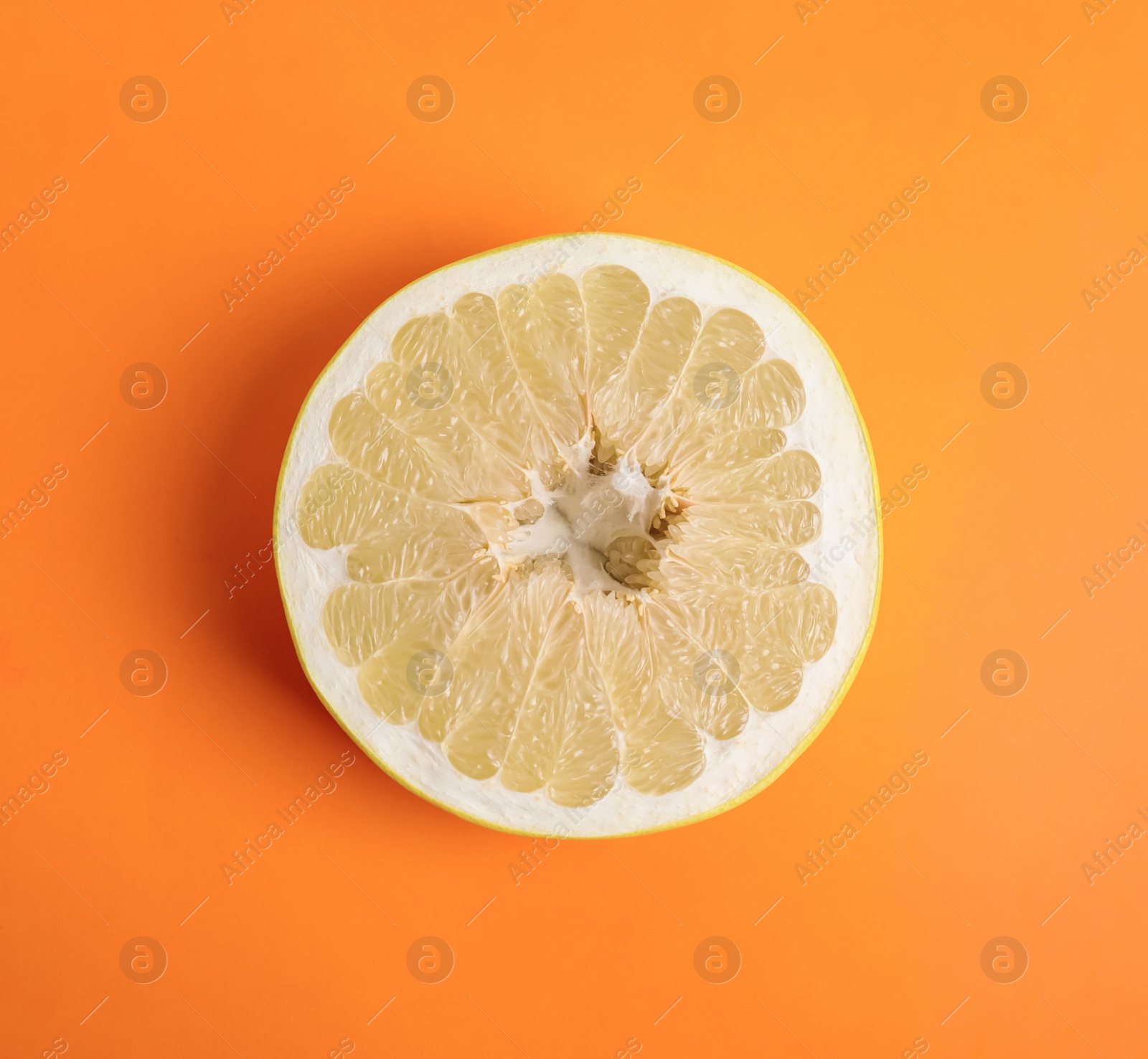 Photo of Fresh cut pomelo fruit on orange background, top view