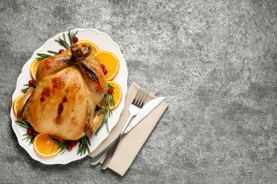 Delicious cooked turkey served on grey table, flat lay with space for text. Thanksgiving Day celebration