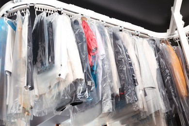 Hangers with clothes on garment conveyor at dry-cleaner's