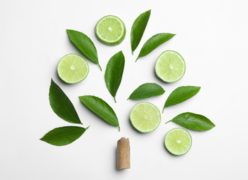 Composition with fresh green citrus leaves and lime slices on white background, top view