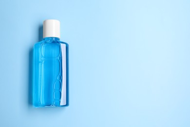Fresh mouthwash in bottle on light blue background, top view. Space for text