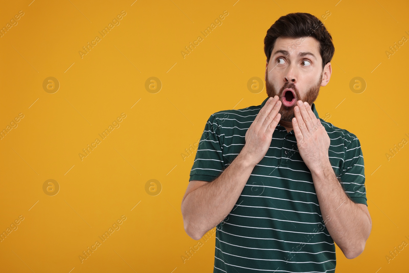 Photo of Portrait of surprised man on yellow background, space for text