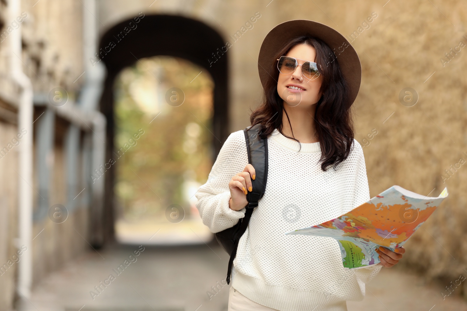 Photo of Traveler with map and backpack on city street