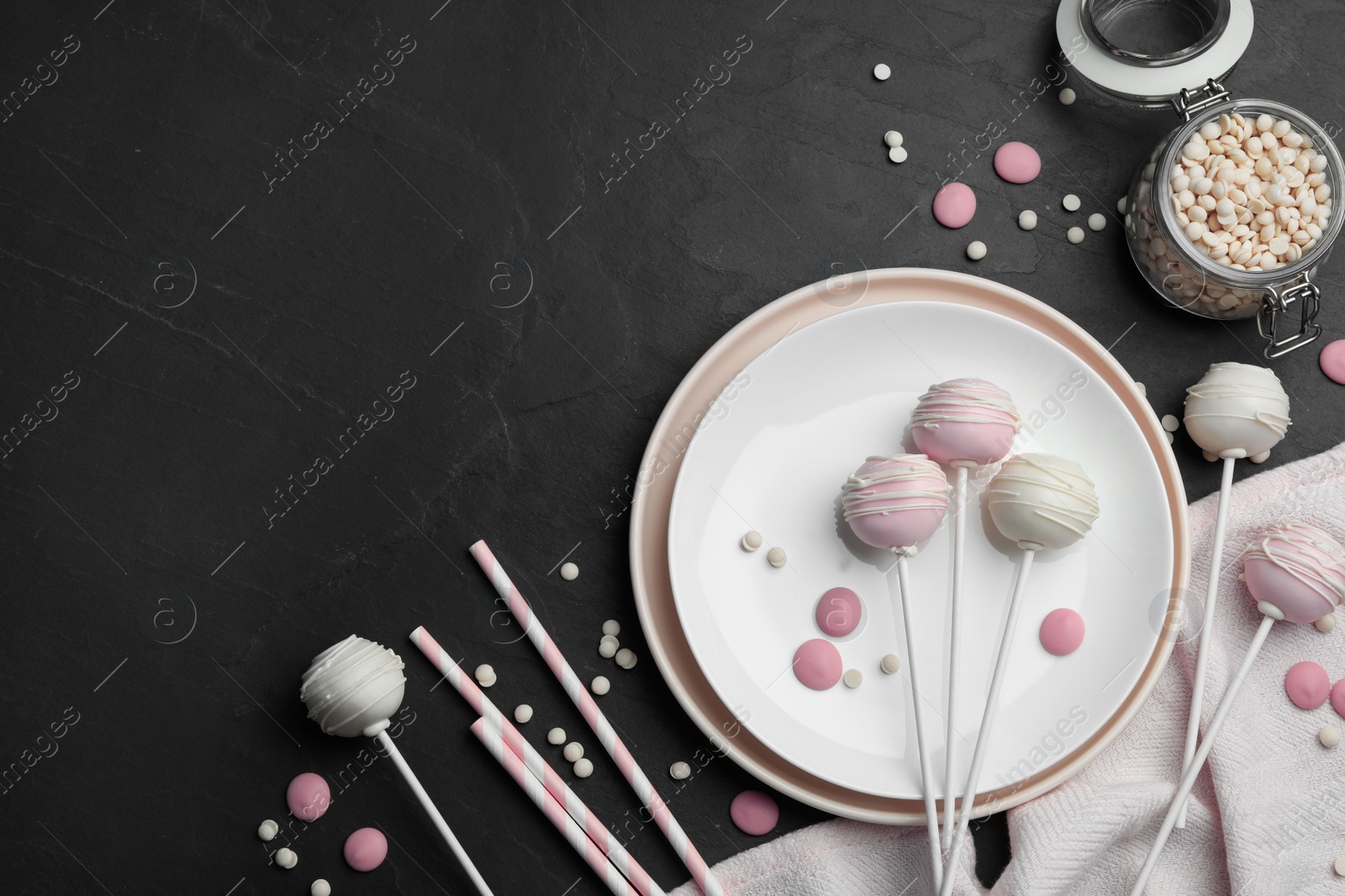 Photo of Sweet cake pops on black background, flat lay. Space for text