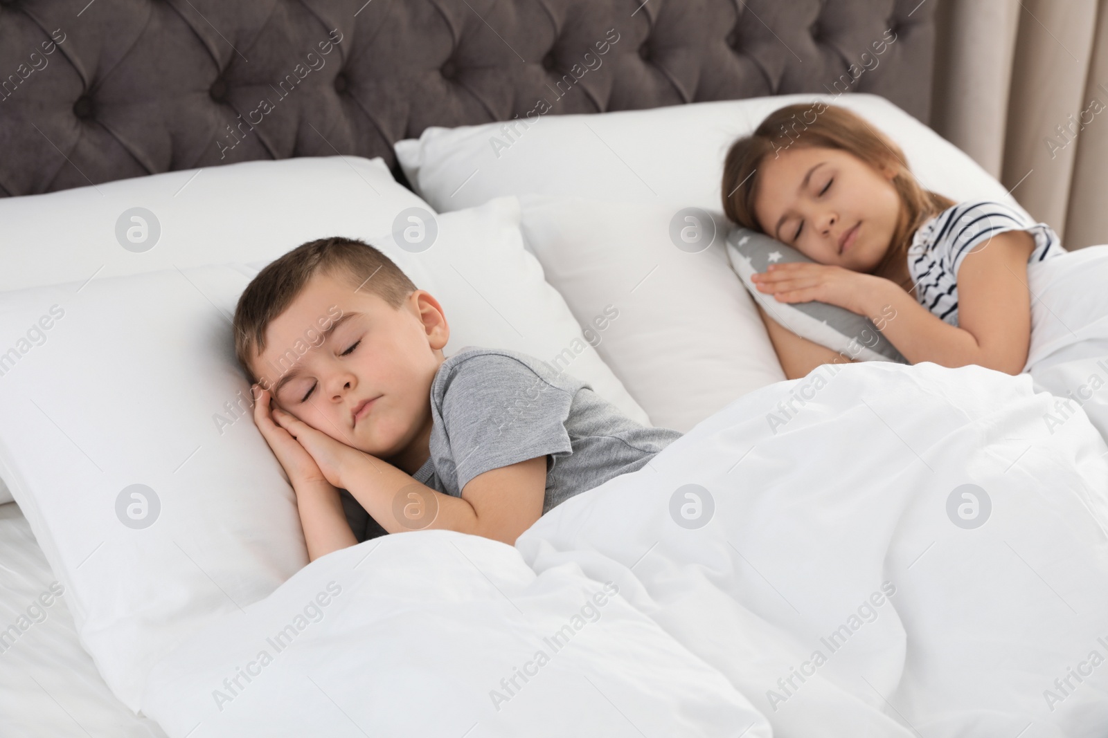 Photo of Cute little children sleeping in comfort bed