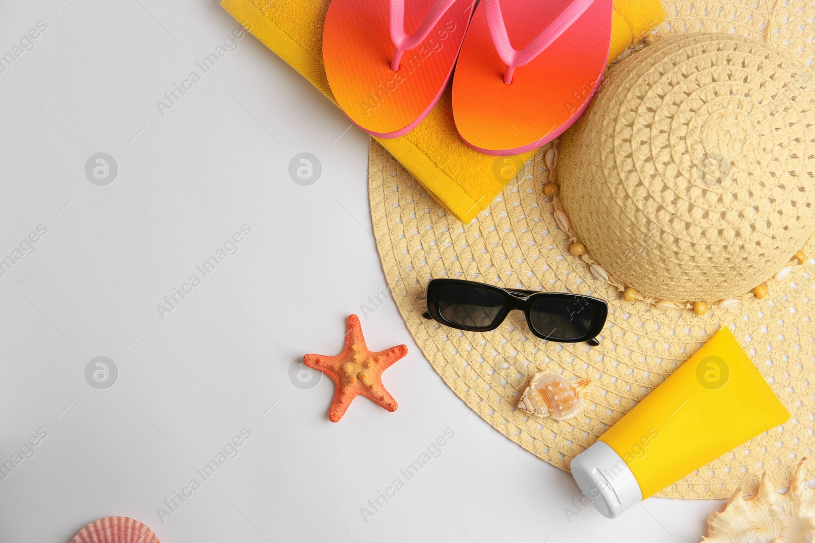 Photo of Flat lay composition with sunscreen and beach accessories on white background, space for text