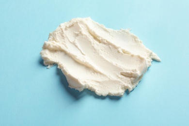 Photo of Smear of tasty cream cheese on color background