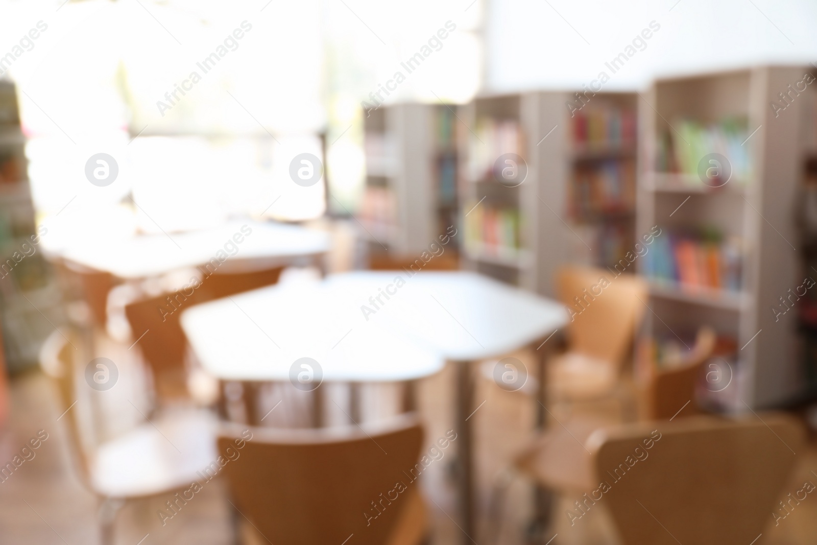 Photo of Blurred view of library interior with bookcases and tables