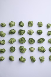 Many fresh green broccoli pieces on white background, flat lay