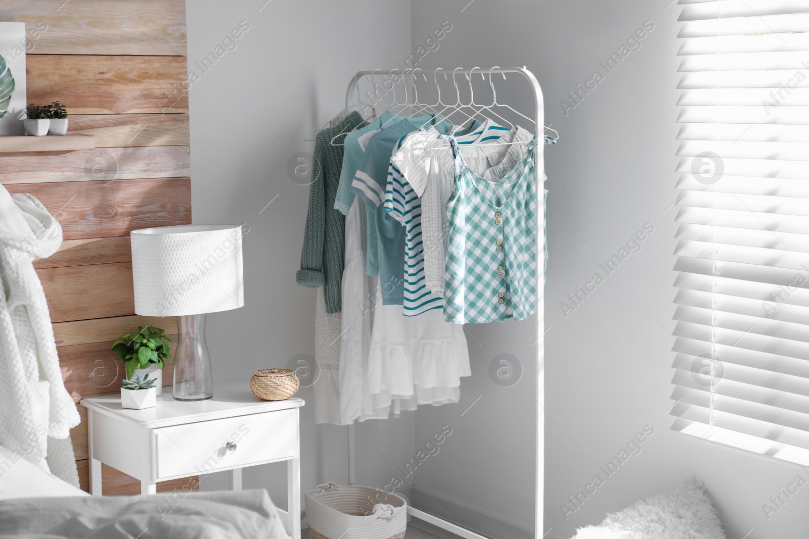 Photo of Rack with stylish women's clothes in modern room. Interior design