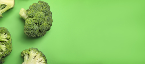 Image of Flat lay composition with fresh broccoli on green background, space for text. Banner design 