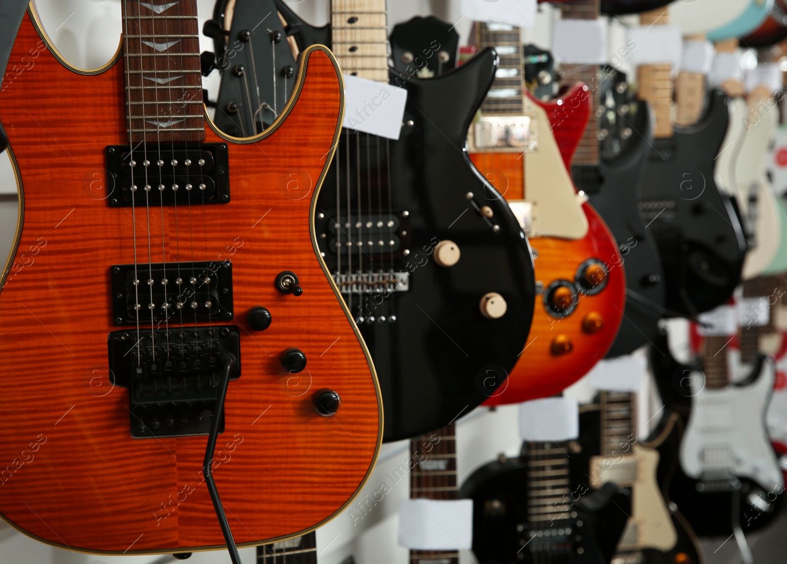 Photo of Row of different guitars in music store, closeup