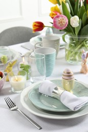 Photo of Easter celebration. Festive table setting with beautiful flowers and painted eggs