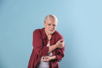 Photo of Mature woman having heart attack on color background