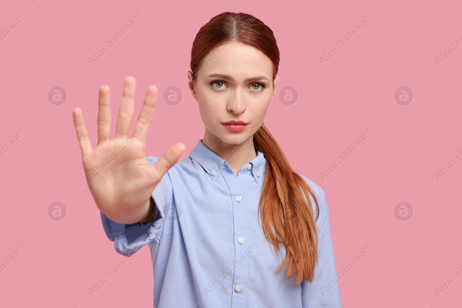 Photo of Woman showing stop gesture on pink background