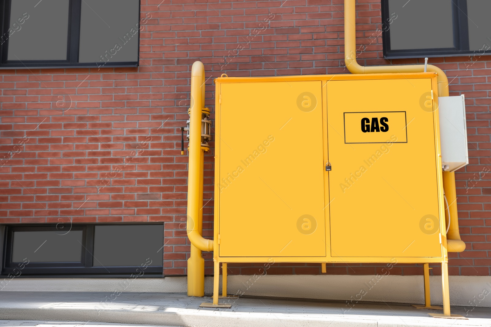 Photo of Gas distribution system with pipes near red brick wall outdoors