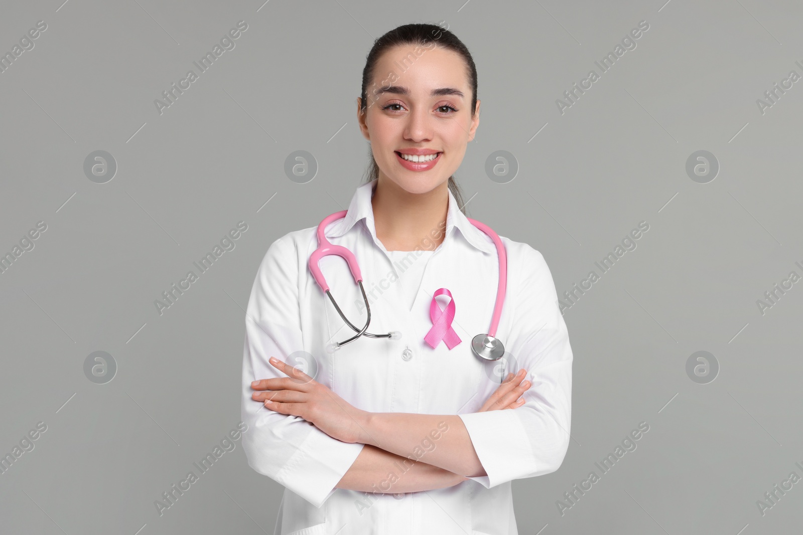 Photo of Mammologist with pink ribbon on gray background. Breast cancer awareness