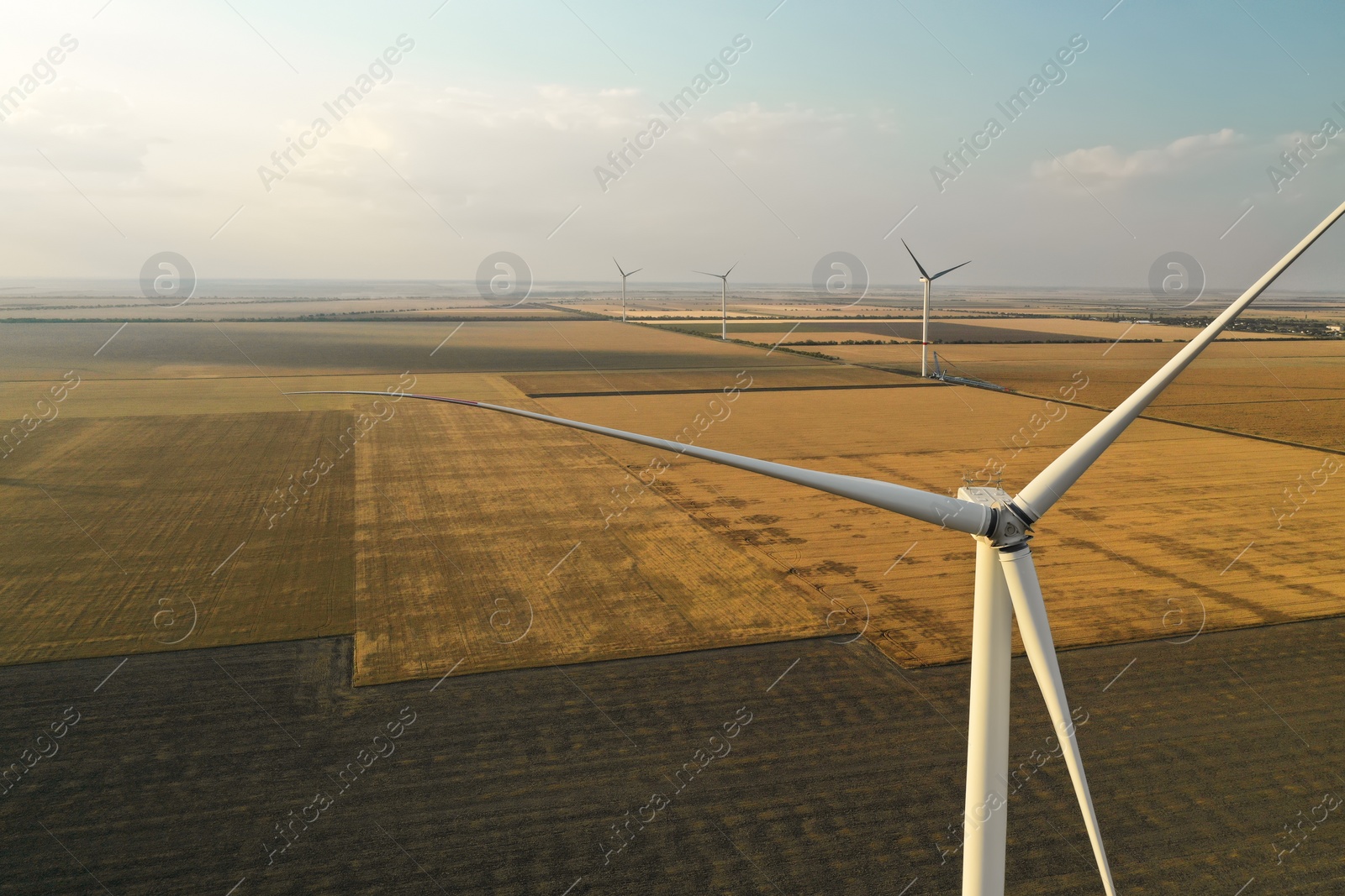 Photo of Modern windmill in wide field. Energy efficiency