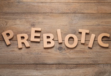 Word Prebiotic made of wooden letters on table, flat lay