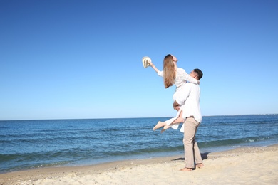 Photo of Lovely couple having fun on sea beach. Space for text