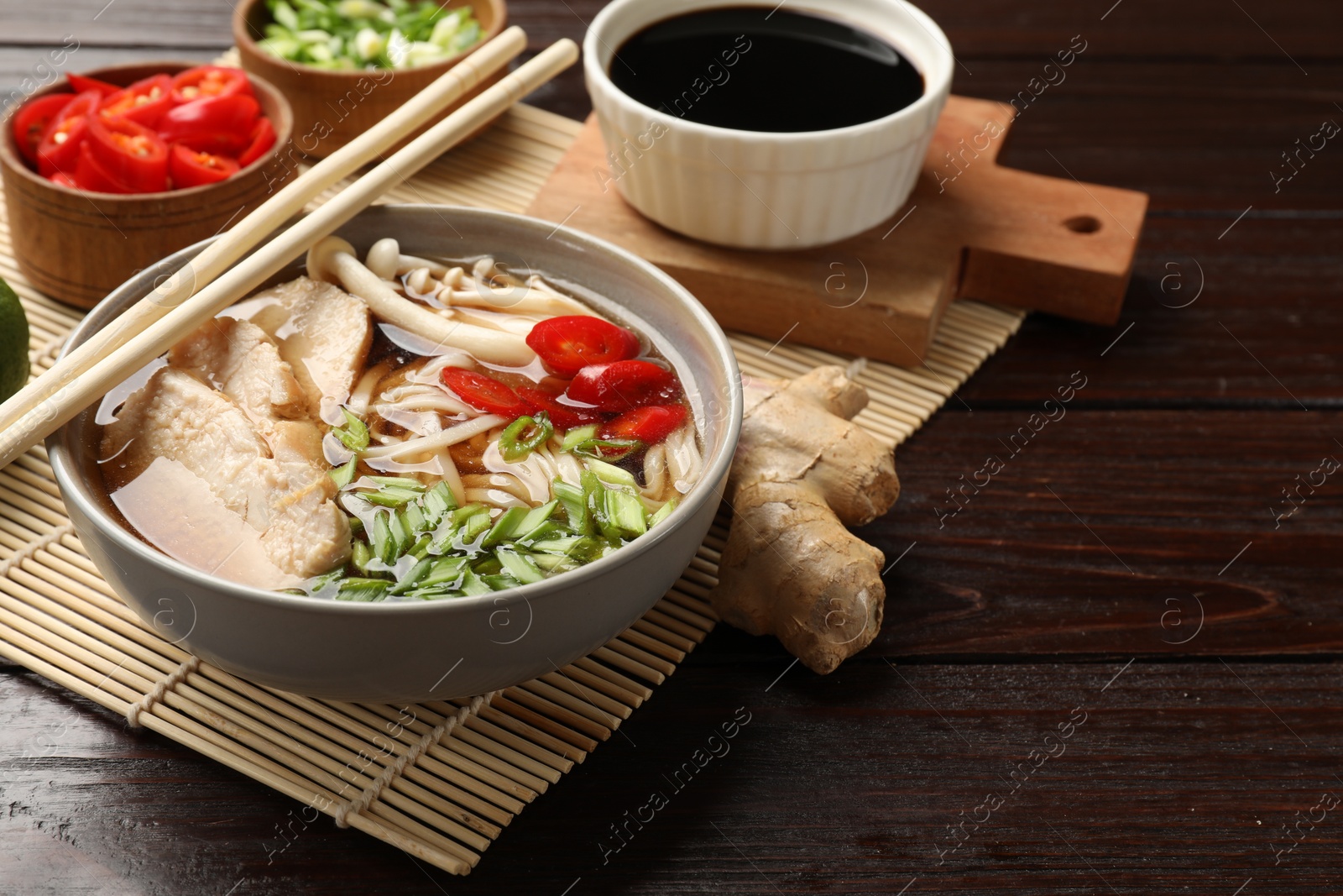 Photo of Delicious ramen with meat and ingredients on wooden table. Noodle soup