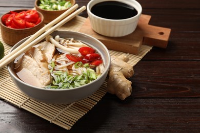 Photo of Delicious ramen with meat and ingredients on wooden table. Noodle soup