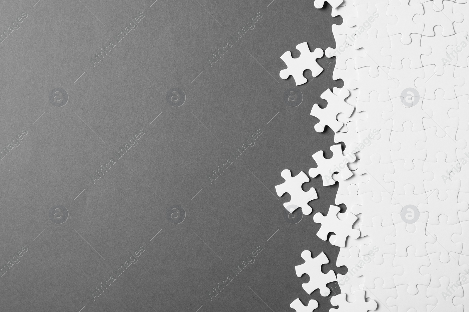Photo of Blank white puzzle pieces on grey background, flat lay. Space for text