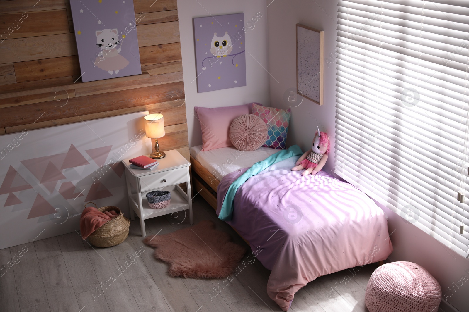 Photo of Bed with beautiful linens in children's room. Modern interior design